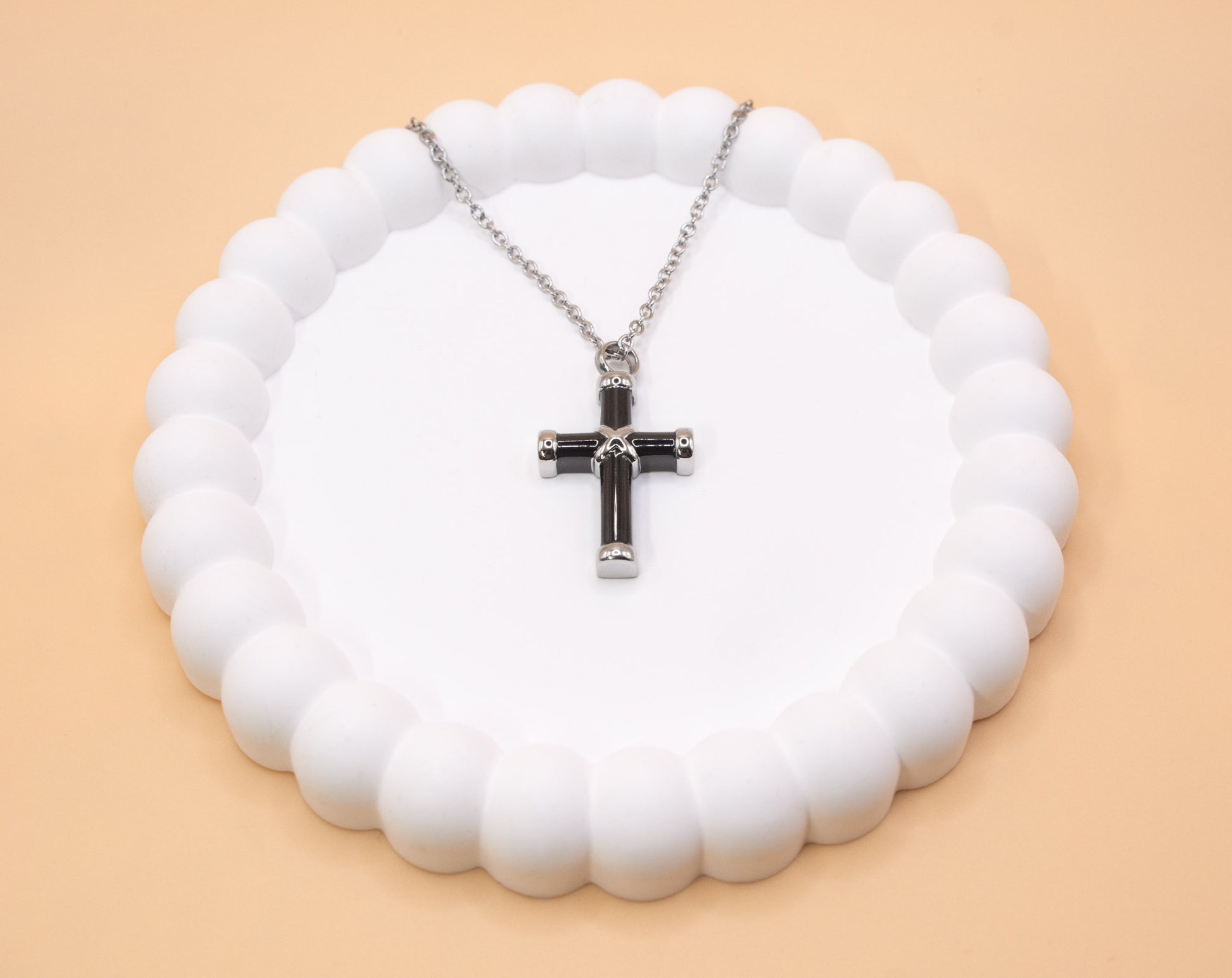 An alternative view of the black and silver stainless steel cross pendant, which can be self-filled with cremation ashes or sand from a loved ones favourite beach